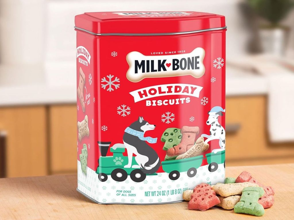 Milk Bone Holiday Tin sitting on counter with dog treats in front of it