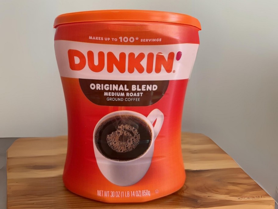 large container of Dunkin' original blend medium roast ground coffee sitting on table