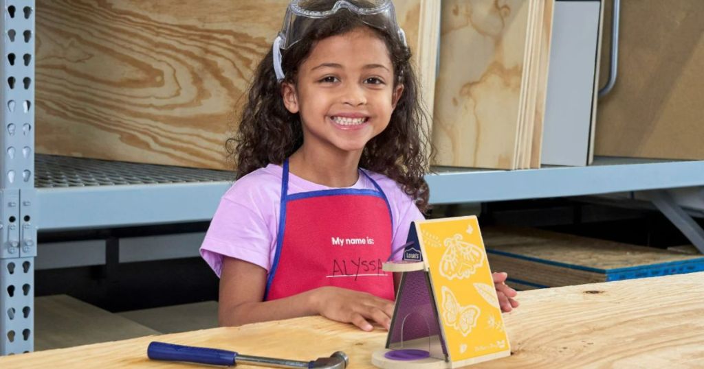 little girl smiling after building a Butterfly Biome at a Lowe's Kids Workshop