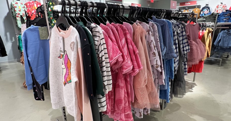 rack of girls tops and dresses in store