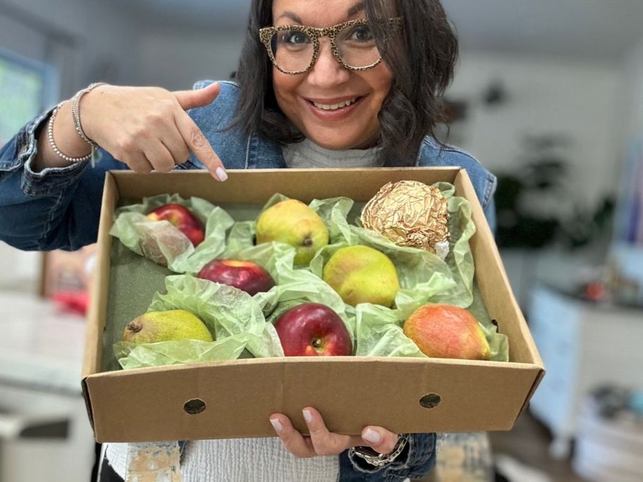 A woman holding a Harry & David Pears & Apples Gift Box