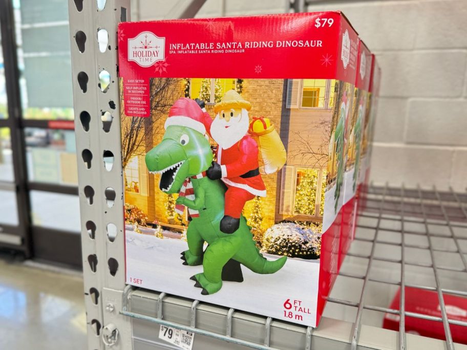 Holiday Time Inflatable Santa Riding Dinosaur on store shelf