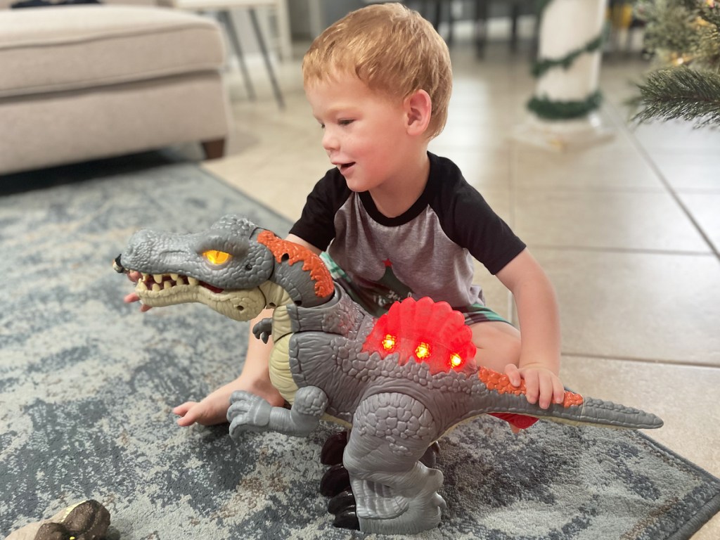 boy playing with light up dinosaur toy