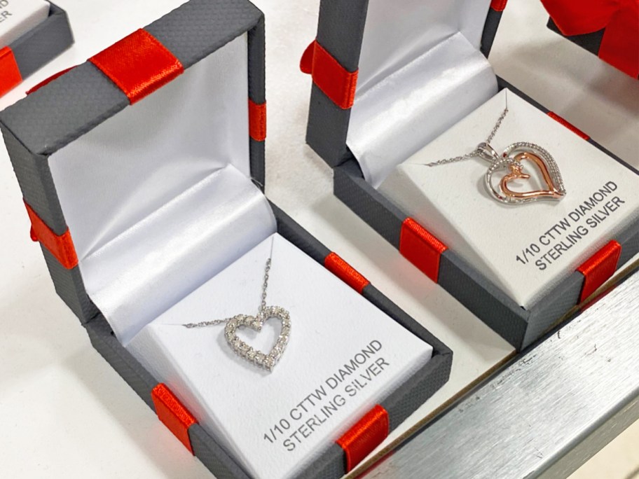 heart necklaces in black jewelry boxes with red bows