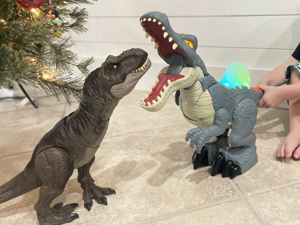 boy playing with two Jurassic Park dino toys