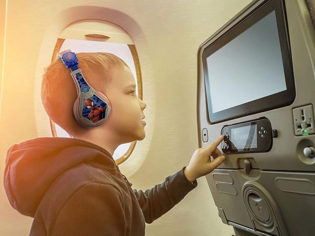Little boy on airplane wearing Spiderman headphones 