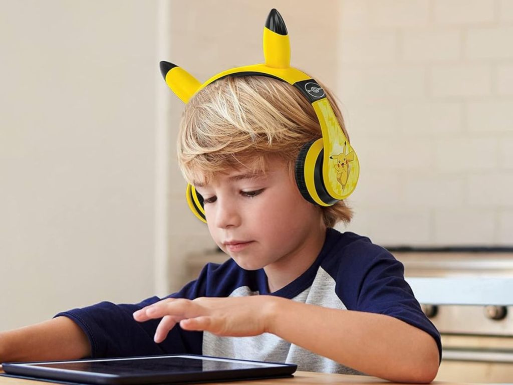 Boy wearing pokemon while playing on a tablet 
