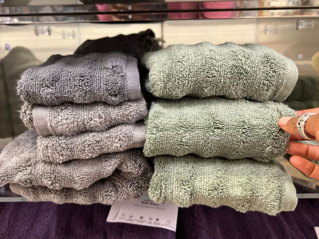 grey and green ribbed hand towels stacked on display shelf