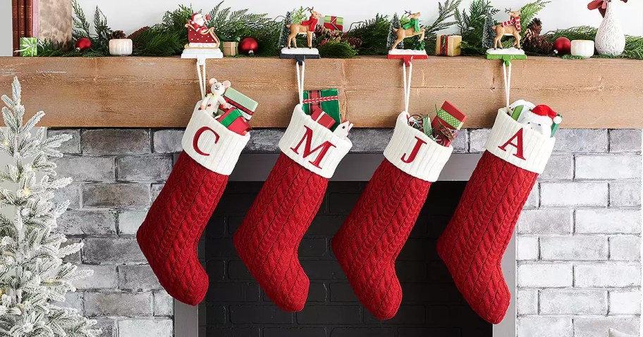 red cable knit christmas stockings hanging from fireplace mantel