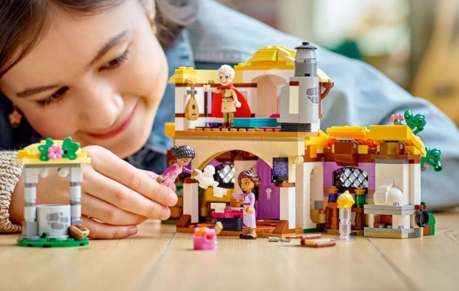a little girl playing with a lego castle building set