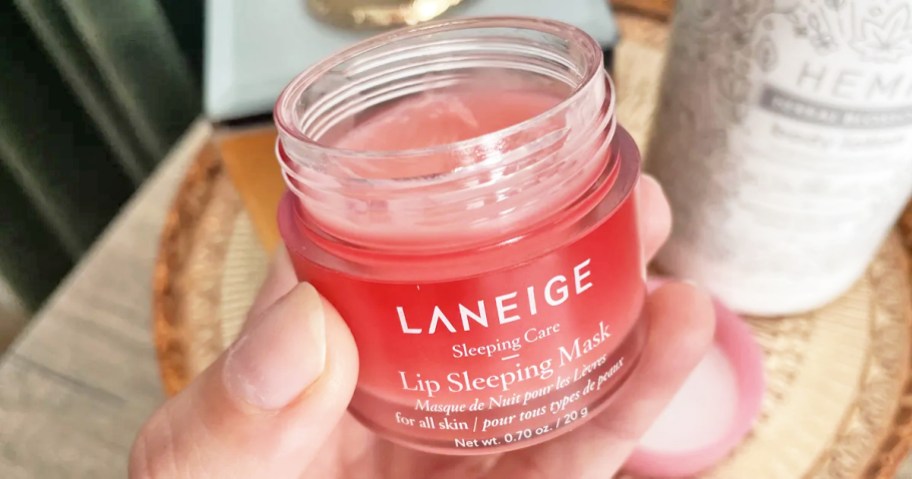 hand holding opened pink jar of Laneige Lip Sleeping Mask