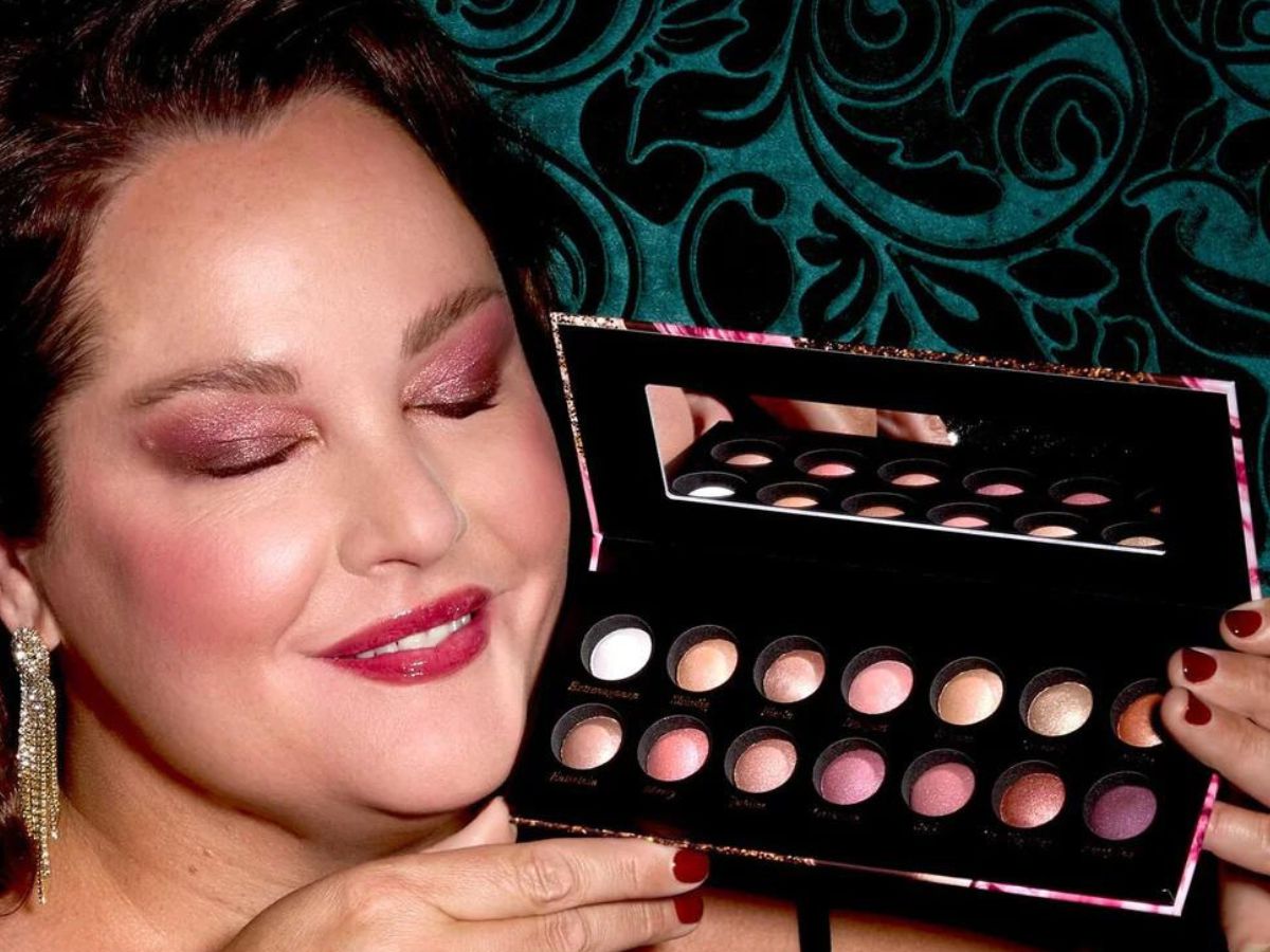 Woman holding Laura Geller The Delectables Palette next to her face with her eyes closed to show the eyeshadow