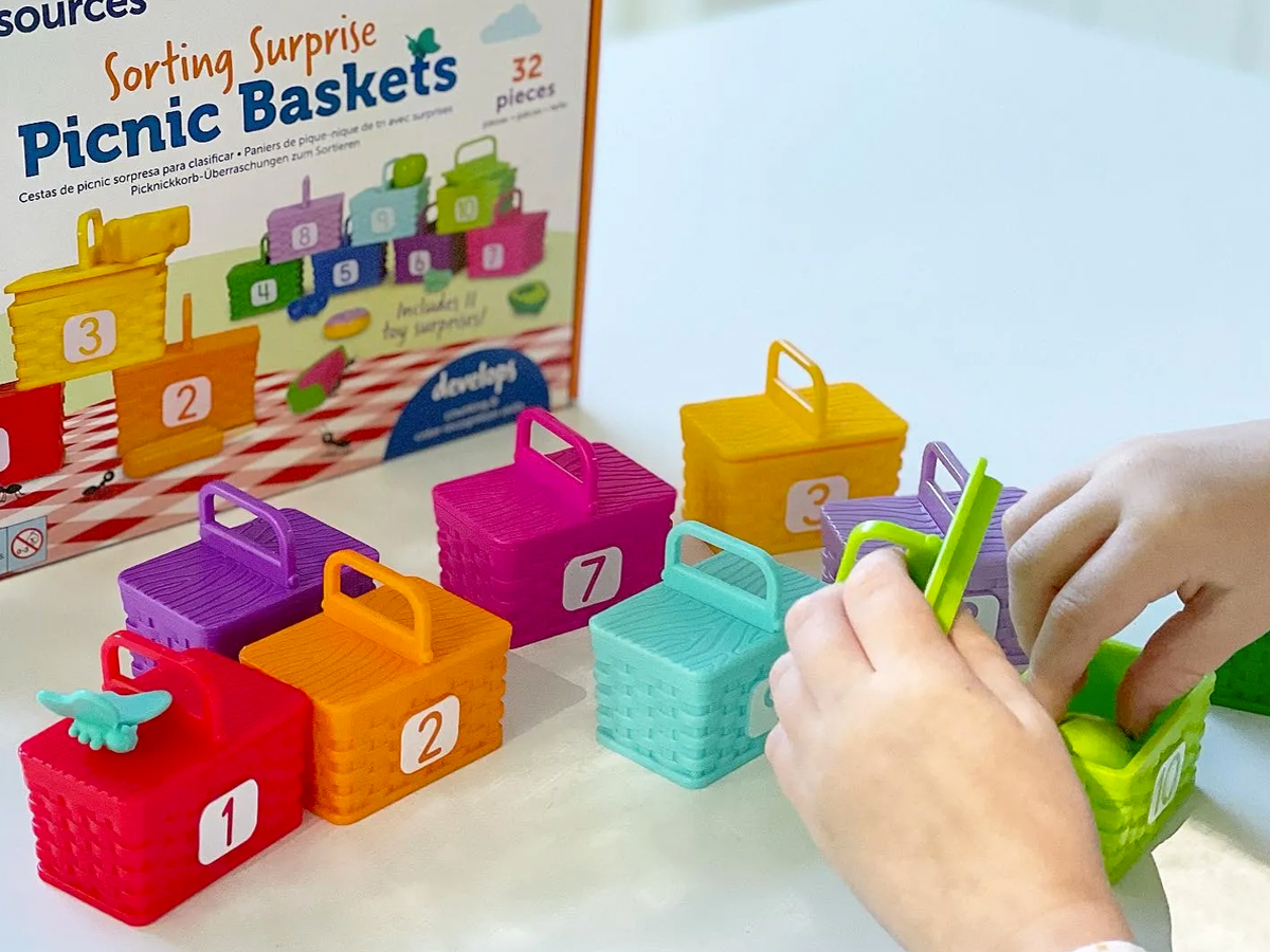 child playing with colorful numbered picnic baskets toy