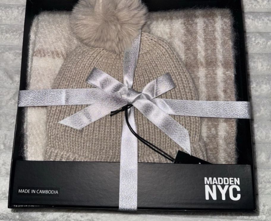 A taupe hat and scarf gift set in a box with a silver ribbon