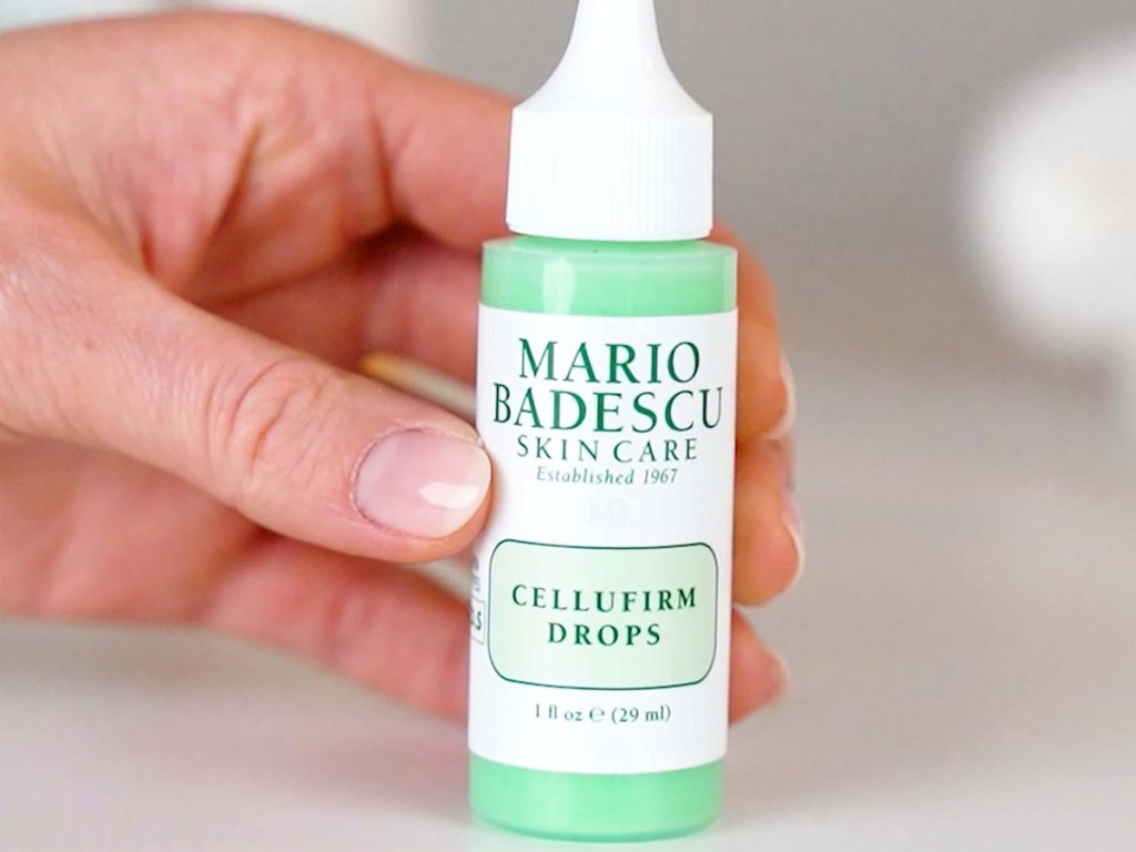 hand holding a small green and white bottle of Mario Badescu Cellufirm Drops
