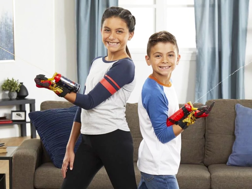 two kids wearing spider-man web slingers on their arms