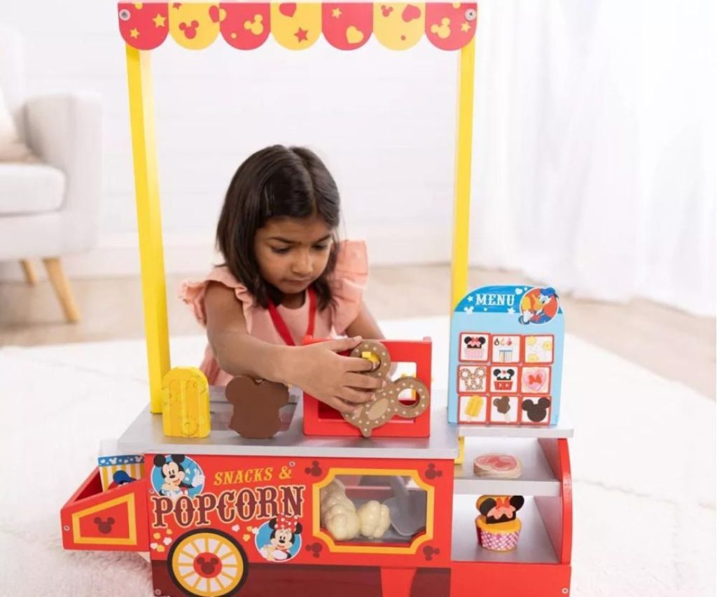 Little girl playing with the Melissa & Doug Disney snack stand