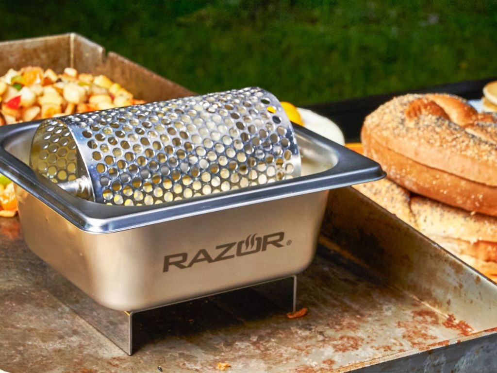 A Mr BBQ butter roller set next to a pile of bagels near a griddle