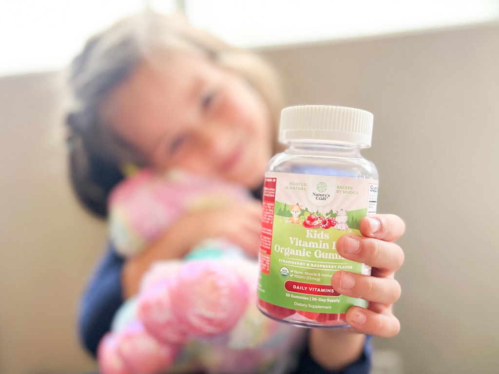 girl holding up bottle of Nature's Craft Kids Organic Vitamin D Gummies