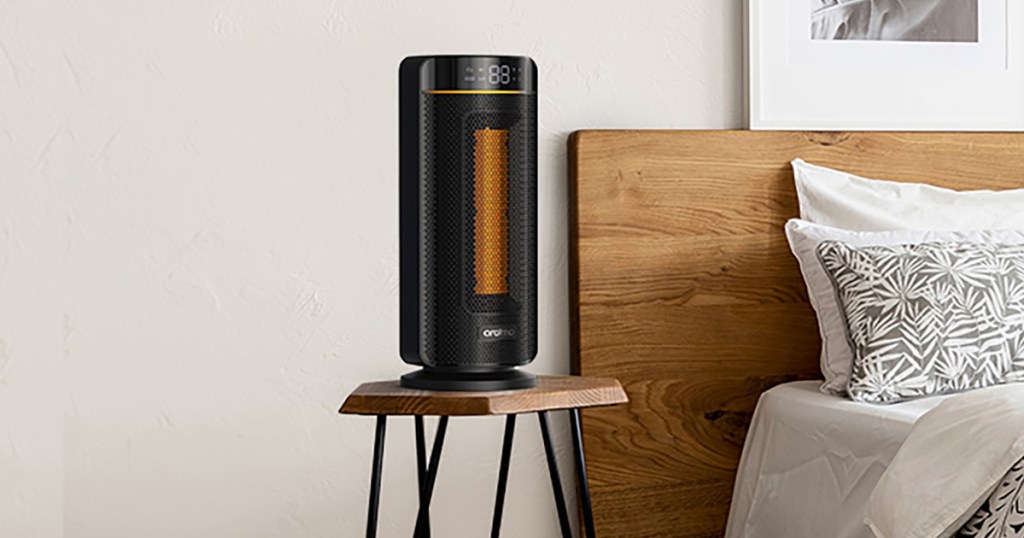 black portable space heater on nightstand next to bed