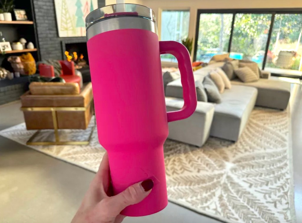 Hand holding a hot pink Tumbler mug with handle