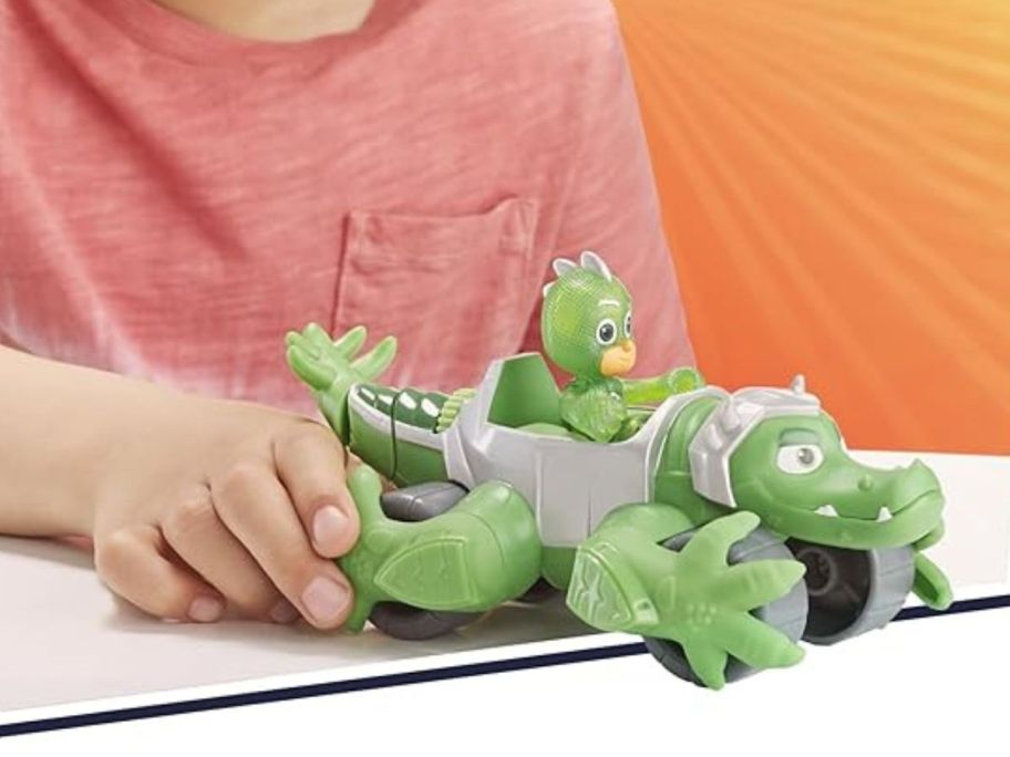 A child playing with PJ Masks Animal Power Gekko Animal Rider Toy Car