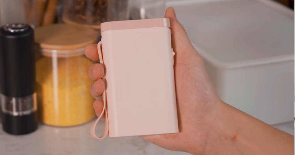 person holding Pink Label Maker in kitchen