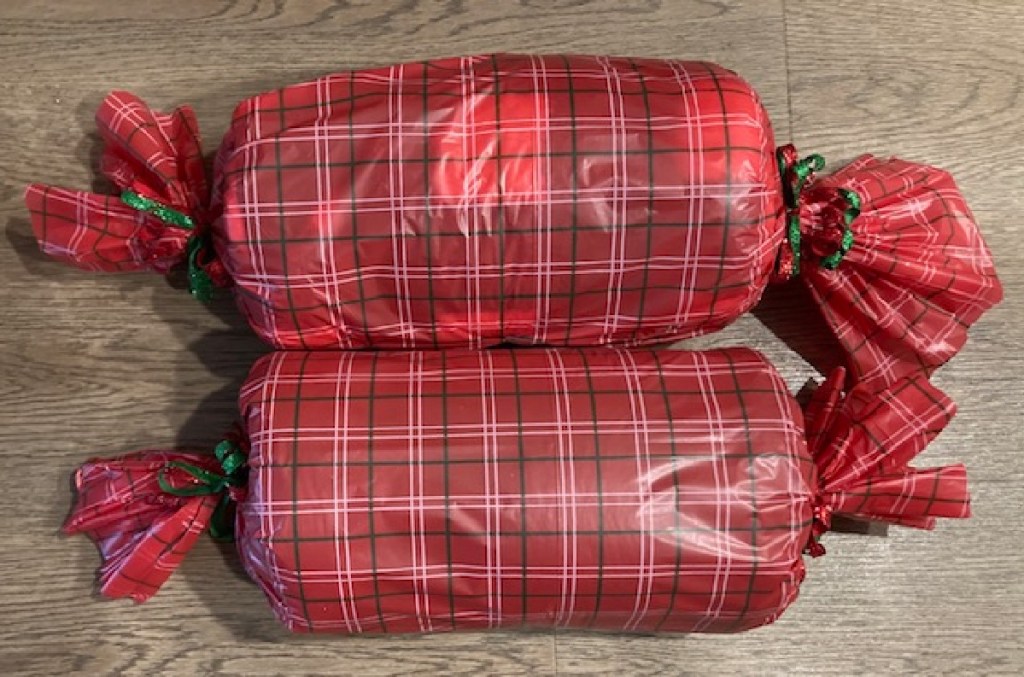 Presents wrapped in Dollar Tree tablecloth to save money on gift wrapping