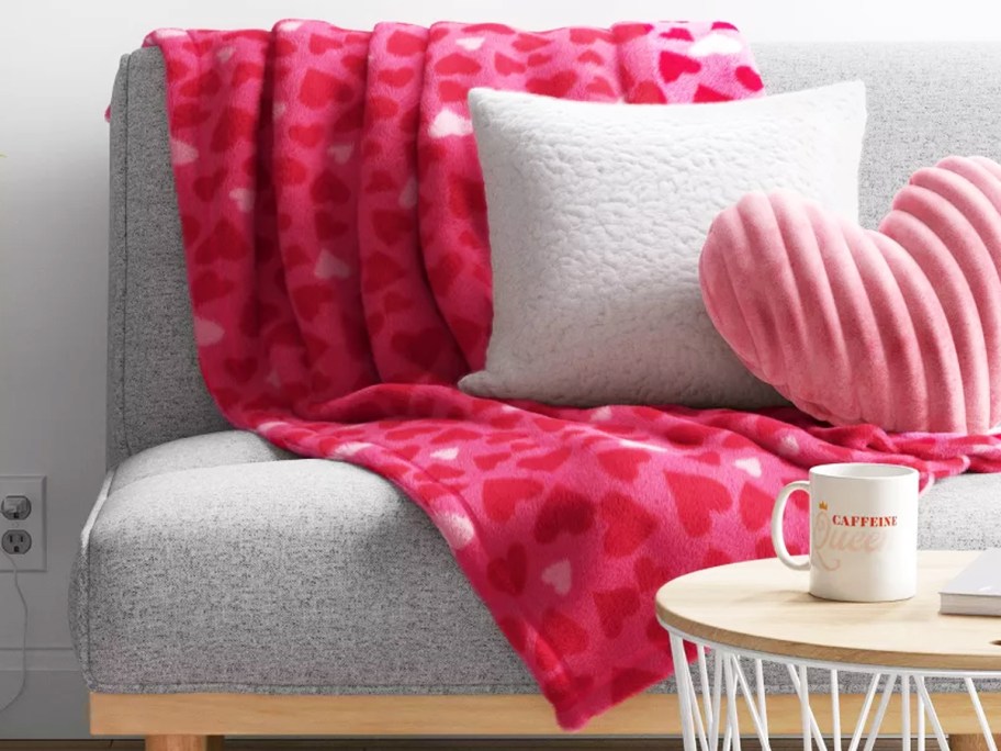 pink heart print throw blanket on couch with throw pillows