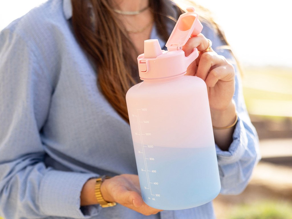 woman holding a large pink and blue water jug