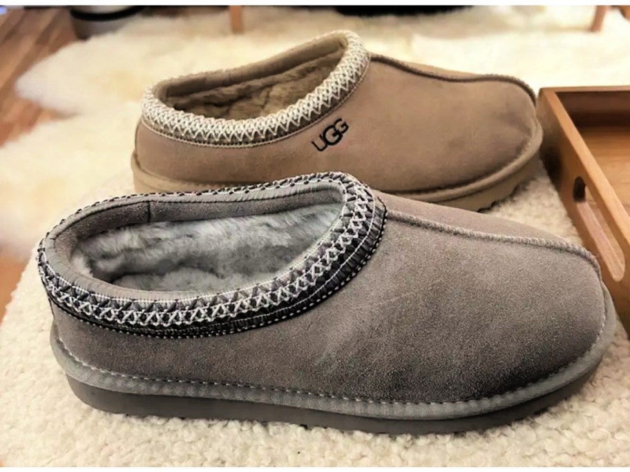 Brown UGG slippers next to gray slip on slippers