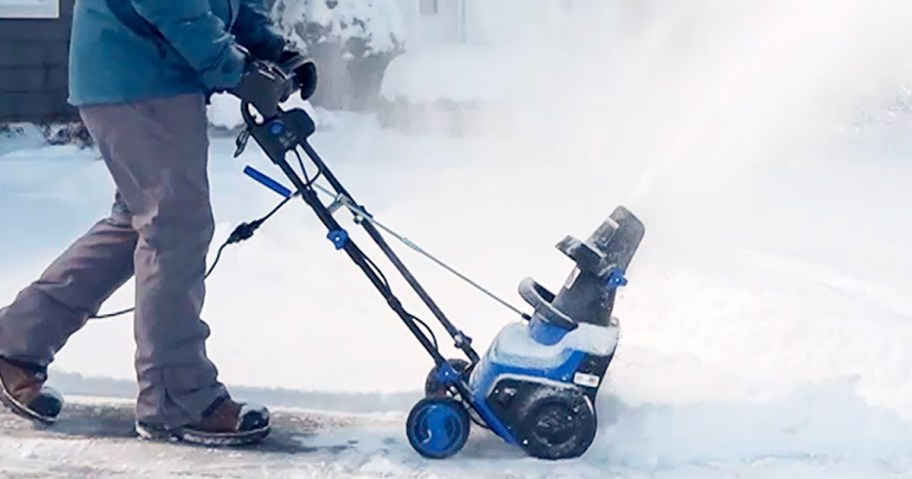 person using a blue snow blower to clear pathway