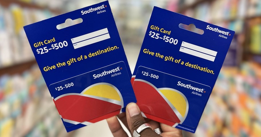 hand holding up two blue Southwest Airlines gift cards