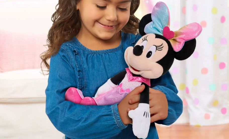 a little girl snuggling a minnie mouse doll