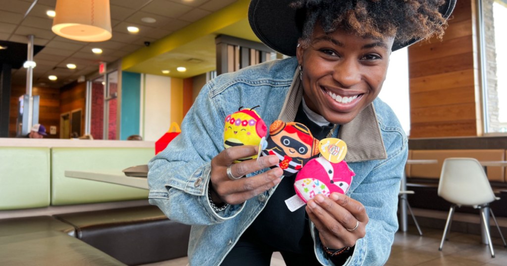 woman holding Squishmallows Happy Meal Characters in mcdonalds