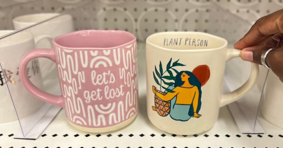 let's get lost and plant person target coffee mugs on store shelf