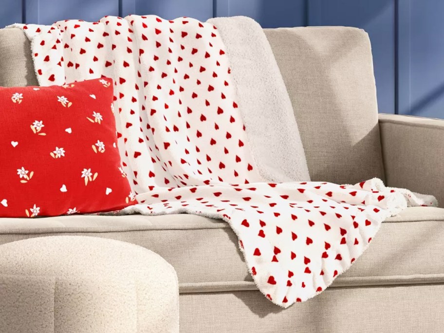 white and red heart print throw blanket draped over couch