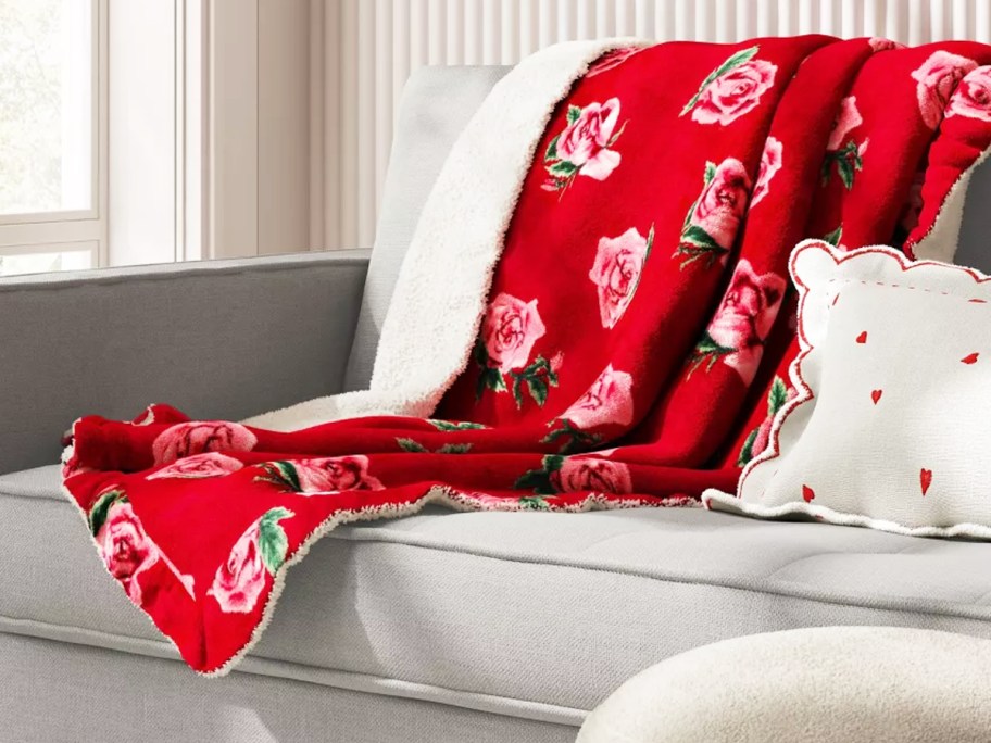 red blanket with pink rose print draped over couch