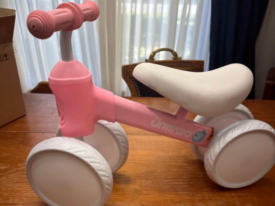 A pink toddler balance bike 