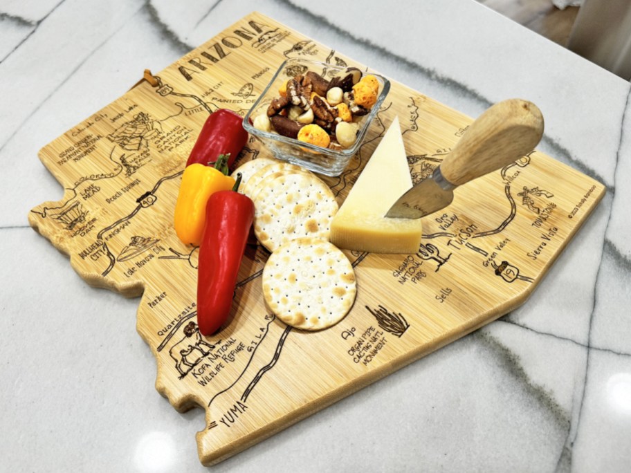Arizona cutting board with cheese, crackers, and peppers on top