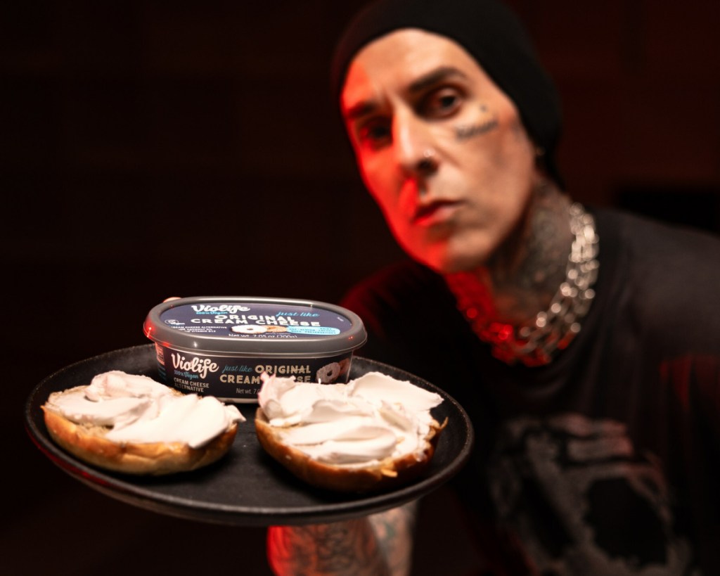 Travis Barker holding Violife Cream Cheese and Dave's Killer Bread Bagels