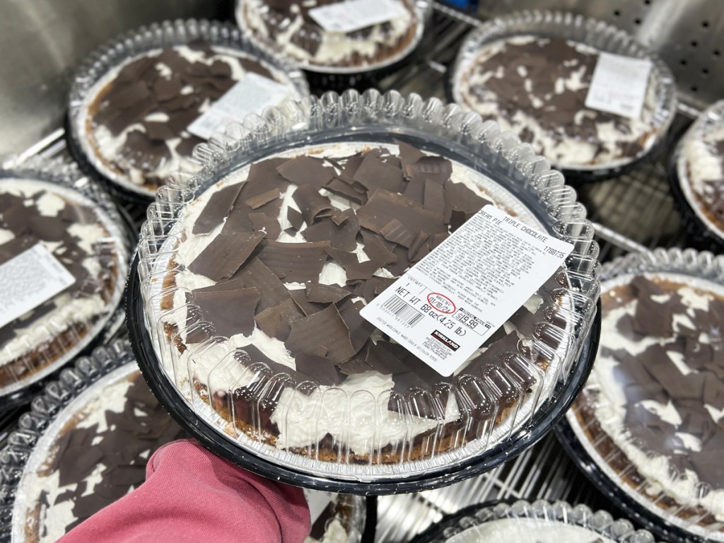 hand holding up a Triple Chocolate Cream Pie from refrigerated case
