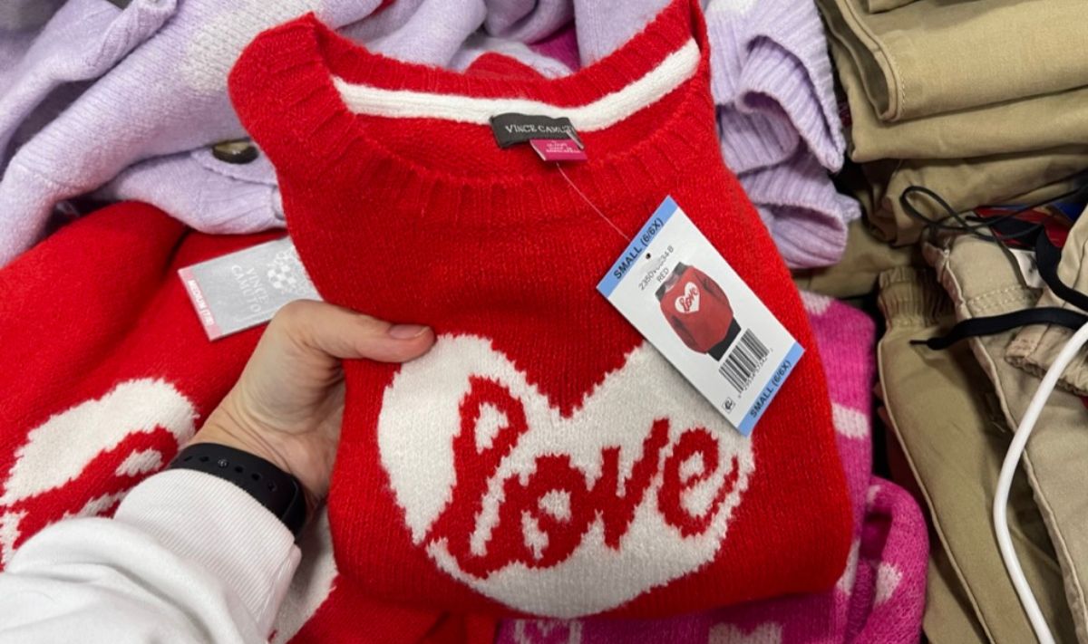 a womans hand displaying a red Vince Camuto Girls Valentines Day Sweater