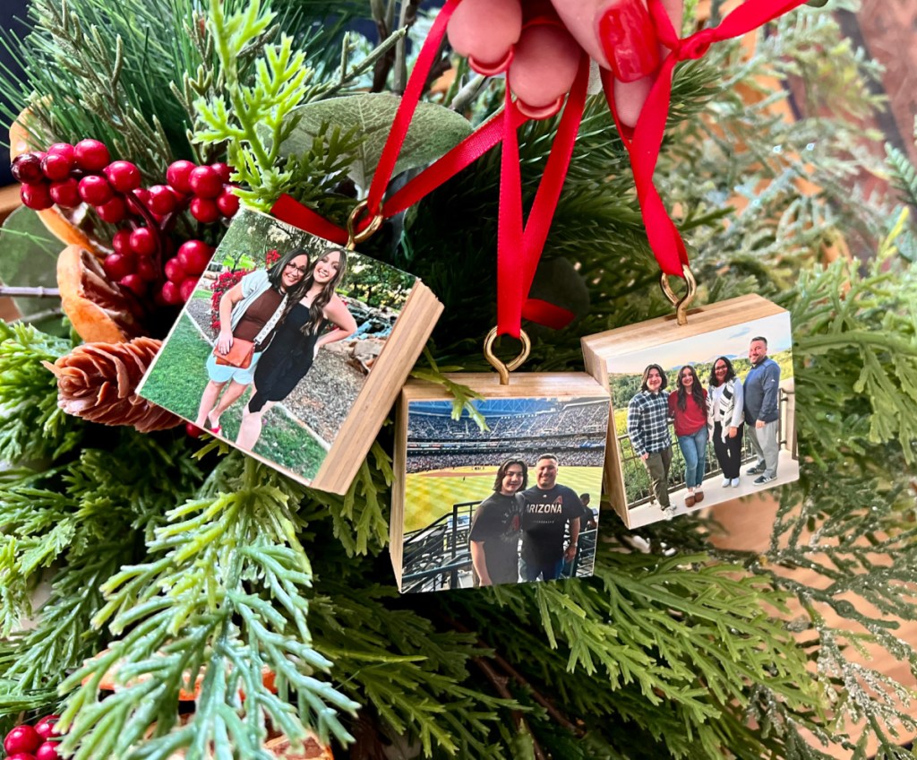 Hand holding up three Walgreens photo ornaments