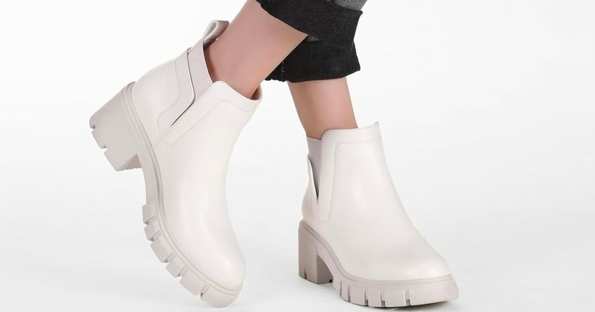 a womans ankles and feet in a pair of white chelsea boots 