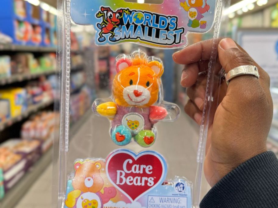 A hand holding a World's Smallest Care Bear