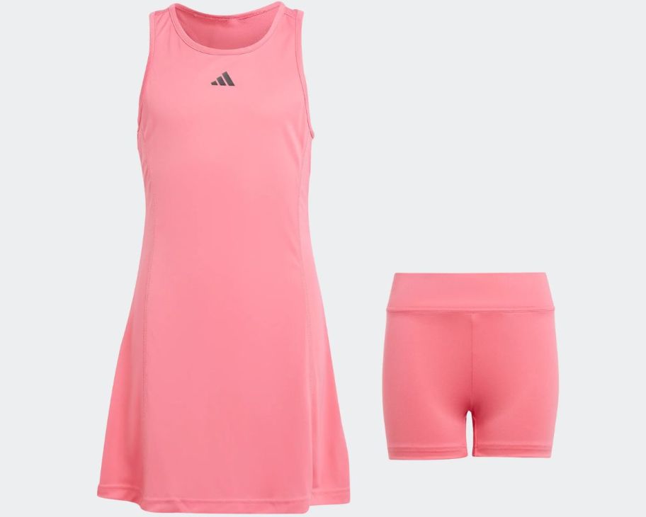 a girls pink tennis dress and shorts on a light gray background