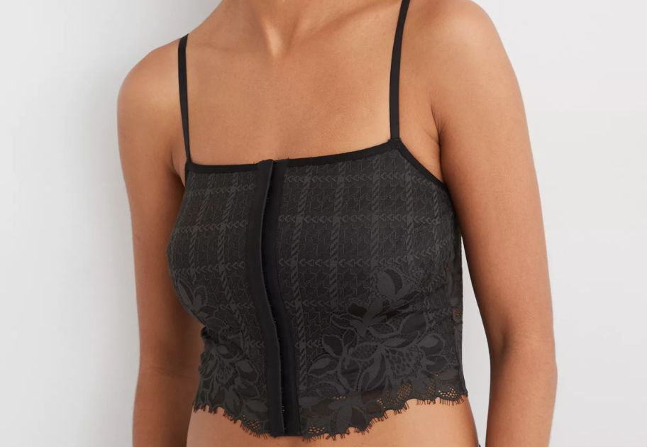 woman wearing a black plaid with lace trim corset style bra top
