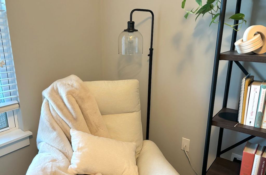 lamp hanging over white chair in corner of room 