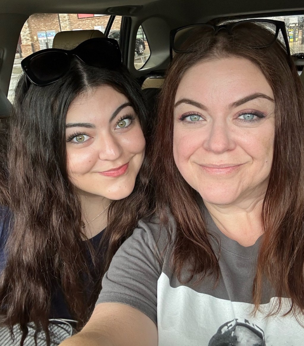 two women sitting in car taking selfie